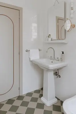 a white bathroom with a sink and a mirror at Parkhotel Mondschein, a Member of Design Hotels in Bolzano