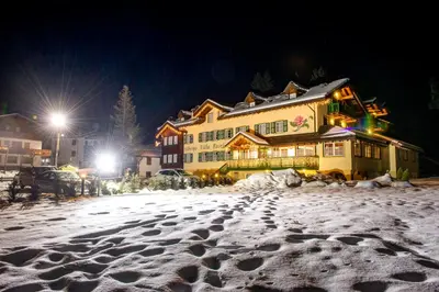 a snow covered street in front of a building at Hotel Villa Rosella Park & Wellness in Canazei