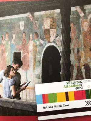 a man and woman looking at a cell phone in front of a mural at Hotel Post Gries in Bolzano