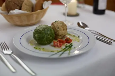 a plate of food with meatballs and vegetables on a table at Hotel Post Gries in Bolzano