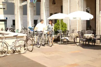 a man and a woman standing next to their bikes at Hotel Post Gries in Bolzano