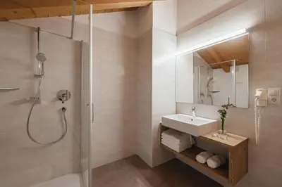 a bathroom with a sink and a mirror at Untermairhof Appartment Residence in Selva dei Molini