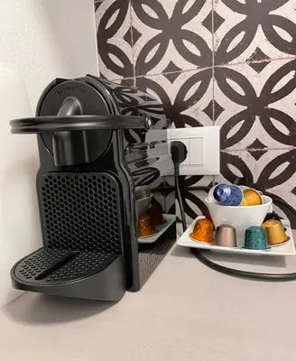 a coffee maker on a counter with a plate of food at Garden Pool Apartment in Merano