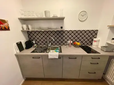 a kitchen with a sink and a counter top at Garden Pool Apartment in Merano