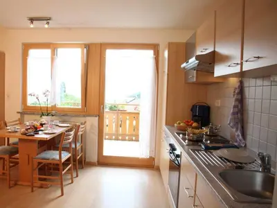 a kitchen with a table and a dining room at Ferienwohnungen Kaltenbachhof - Urlaub auf dem Biobauernhof in Parcines