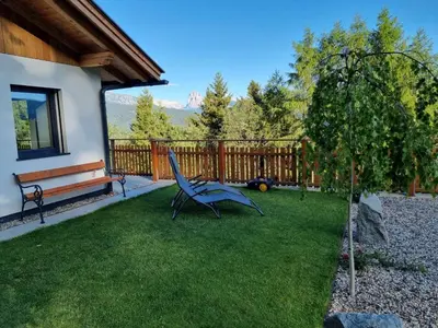 a bench sitting in a yard next to a tree at Alone in Chalet with view on Dolomites in Villandro
