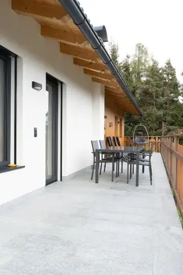 a patio with a table and chairs on it at Alone in Chalet with view on Dolomites in Villandro