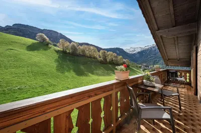 a balcony with a table and chairs and mountains at Treffhof in Siusi