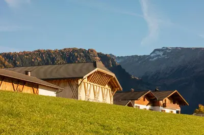 a barn on top of a hill with a green field at Treffhof in Siusi