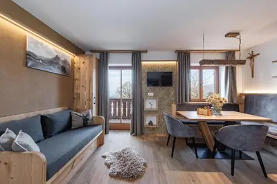 a living room with a blue couch and a table at Treffhof in Siusi