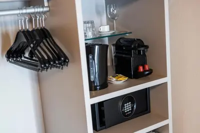 a kitchen cabinet with a microwave and utensils at Stay COOPER l Goethe Guesthouse in Bolzano