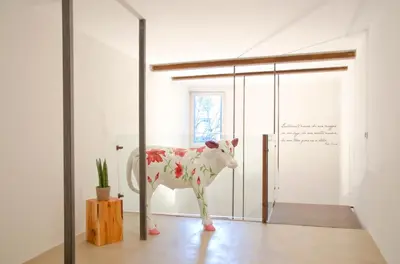 a statue of a cow in a room at Stay COOPER l Goethe Guesthouse in Bolzano