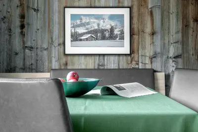 a table with a green bowl with a book on it at Ciasa de Lenz in San Cassiano