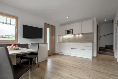 a kitchen and dining room with a table and a television at Ciasa de Lenz in San Cassiano