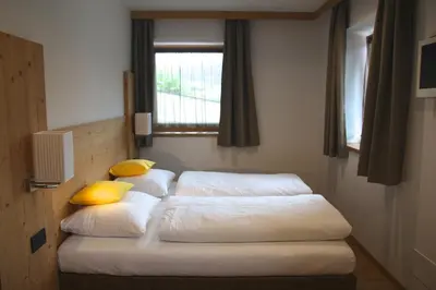 two beds in a room with a window at Ciasa de Lenz in San Cassiano