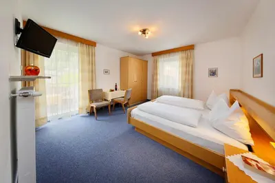 a hotel room with a bed and a table at Pension Siller in Lagundo