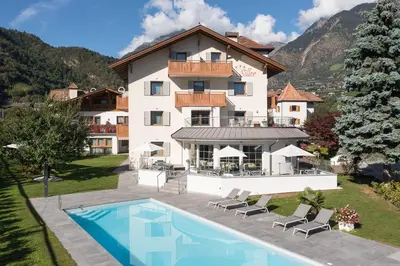 a large house with a swimming pool in front of it at Pension Siller in Lagundo