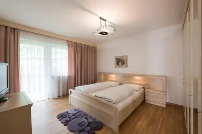 a bedroom with a bed and a large window at Pension Siller in Lagundo