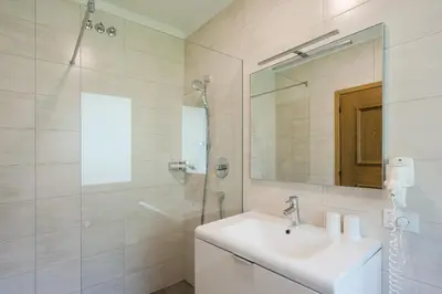 a white bathroom with a sink and a mirror at Pension Siller in Lagundo