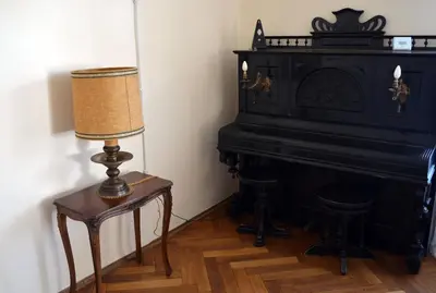 a lamp on a table next to a piano at Villa Iolanda in Merano