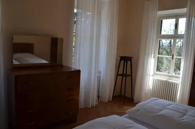 a bedroom with a dresser and a bed and a window at Villa Iolanda in Merano