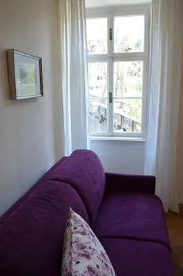a purple couch in a room with a window at Villa Iolanda in Merano