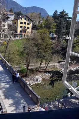 a group of people standing on a bridge near a body of water at Villa Iolanda in Merano