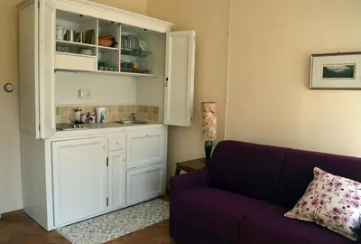 a living room with a purple couch and a kitchen at Villa Iolanda in Merano