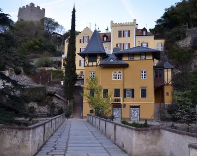 a yellow building on the side of a bridge at Villa Iolanda in Merano