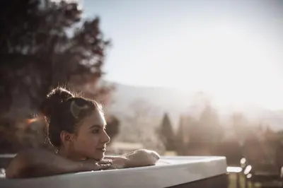 a woman is laying in a sauna at Montis - Active Nature Resort in Brunico