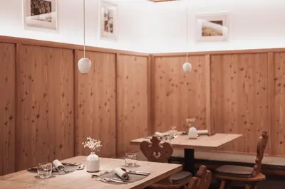 a table with a vase of flowers on top of it at Montis - Active Nature Resort in Brunico