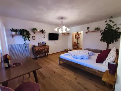 a living room with a bed and a table at Gemütliches Studio mit Garagenparkplatz in Vols am Schlern