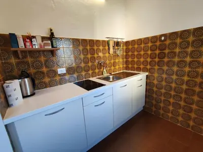a kitchen with a white counter and a sink at Gemütliches Studio mit Garagenparkplatz in Vols am Schlern