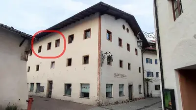 a building with a red circle on the side of it at Gemütliches Studio mit Garagenparkplatz in Vols am Schlern