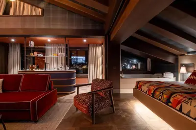 a bedroom with a bed and a couch and a chair at Eight Cortina in Cortina dʼAmpezzo