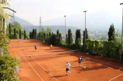 a group of people playing tennis on a tennis court at Parkhotel Marlena - Adults Only in Merano