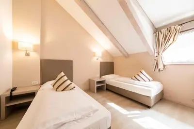 a bedroom with two beds and a window at Business Resort Parkhotel Werth in Bolzano