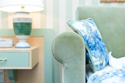a blue and white pillow on a chair with a lamp at Business Resort Parkhotel Werth in Bolzano