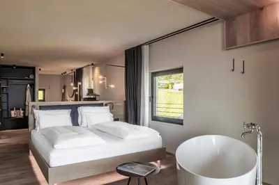 a living room with a couch and a tv at Gloriette Guesthouse Boutiquehotel in Soprabolzano