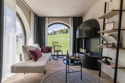 a living room with a couch and a fireplace at Gloriette Guesthouse Boutiquehotel in Soprabolzano