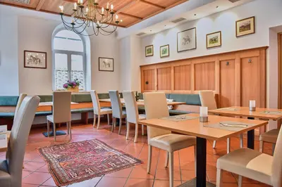 a dining room with wooden tables and chairs at Albergo Cavallino s'Rössl in Merano