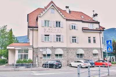 a building with cars parked in front of it at Albergo Cavallino s'Rössl in Merano