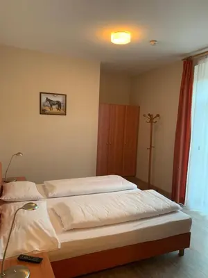 a bedroom with two white beds and a lamp at Albergo Cavallino s'Rössl in Merano