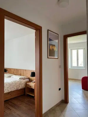 a bedroom with a bed and a window and a mirror at Agritur Maso Forcola in Brez
