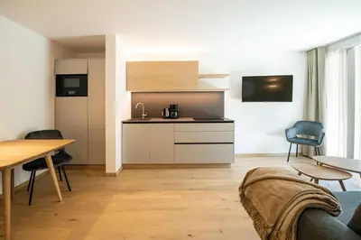 a living room with a table and a kitchen at Residence aMoret in Bressanone
