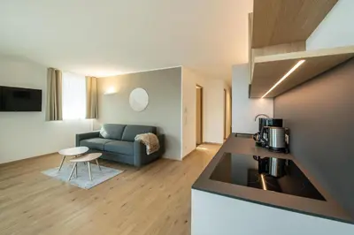 a kitchen and a living room with a couch at Residence aMoret in Bressanone