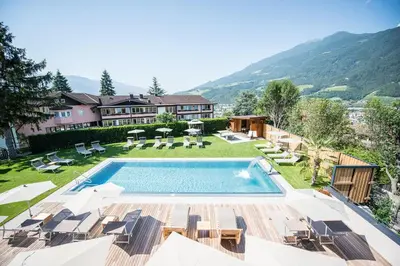 a house with a swimming pool and a yard with chairs at Residence aMoret in Bressanone