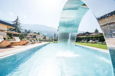 a fountain in a swimming pool at a resort at Residence aMoret in Bressanone