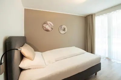a bedroom with a bed and a large window at Residence aMoret in Bressanone