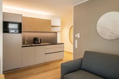 a living room with a couch and a kitchen at Residence aMoret in Bressanone